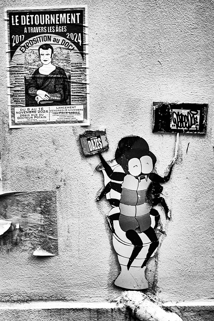 Affiche « Le détournement » et personnage d’insecte collé au mur